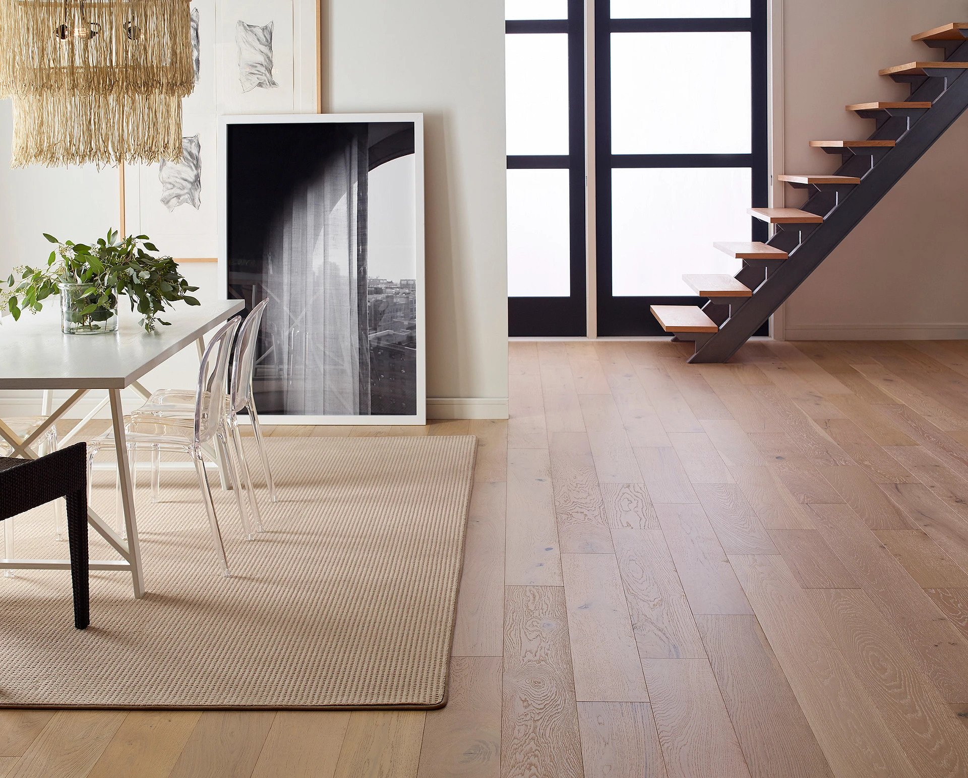 Dining room with table, area rug and stairs in the background